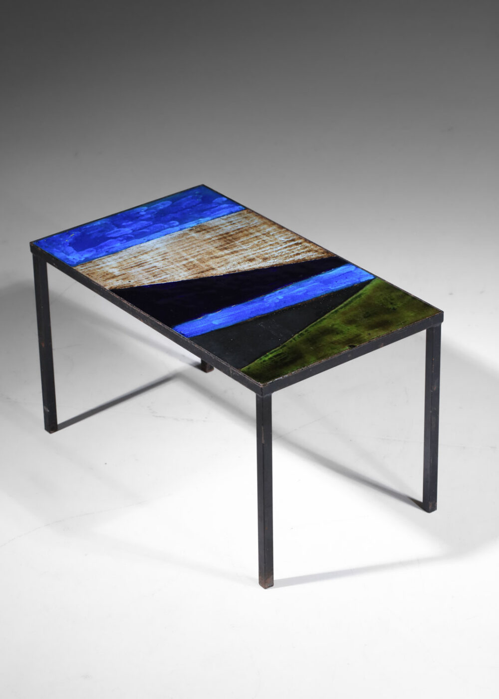 Table basse française des années 50 attribuée aux 2 potiers. Piétement en métal laqué (peinture d'origine) et plateau rectangulaire recouvert de lave émaillée dans des teintes bleues